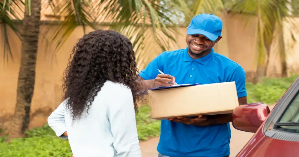 Close-up of delivery person giving parcel client